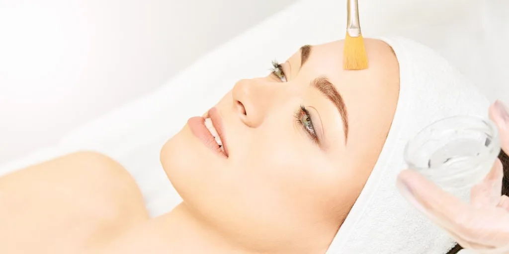 Chemical Peel Side Effects, Types, and Benefits 5 Woman receiving facial chemical peel treatment at Health and Wellness Spa