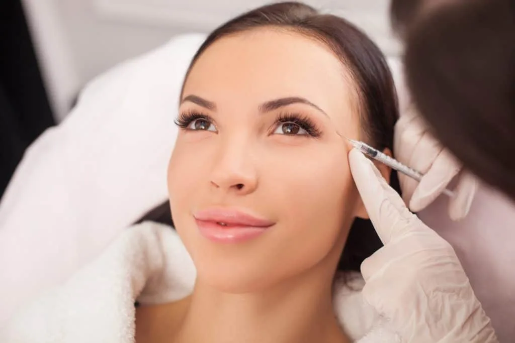 What Are The Differences Between Botox And Dysport? 4 A woman receiving a Botox injection near her eyes for wrinkle reduction